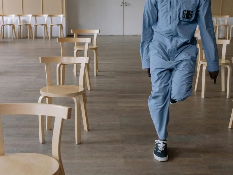 Person performing a smooth, flowing exercise in a minimalist room.